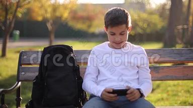 <strong>放学</strong>后，十几岁的男孩在公园的智能手机上玩网络游戏